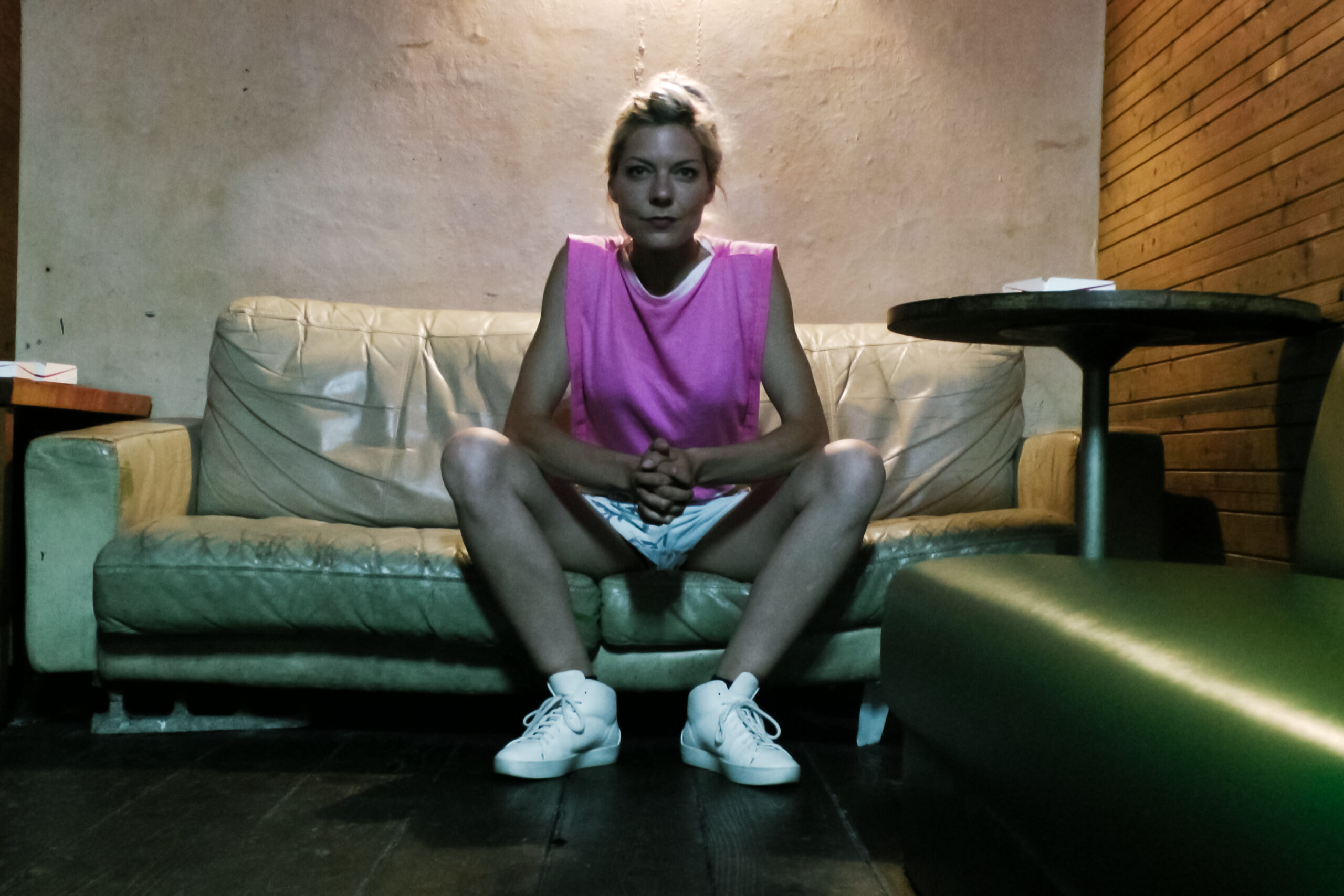 Brigitta Muntendorf sitzt auf einem Sofa in einer Bar