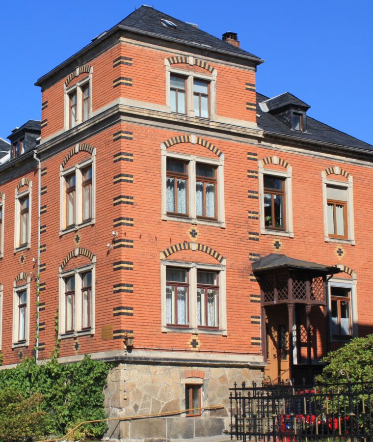 Ein rotes Haus mit Backstein-Fassade und Verzierungen.